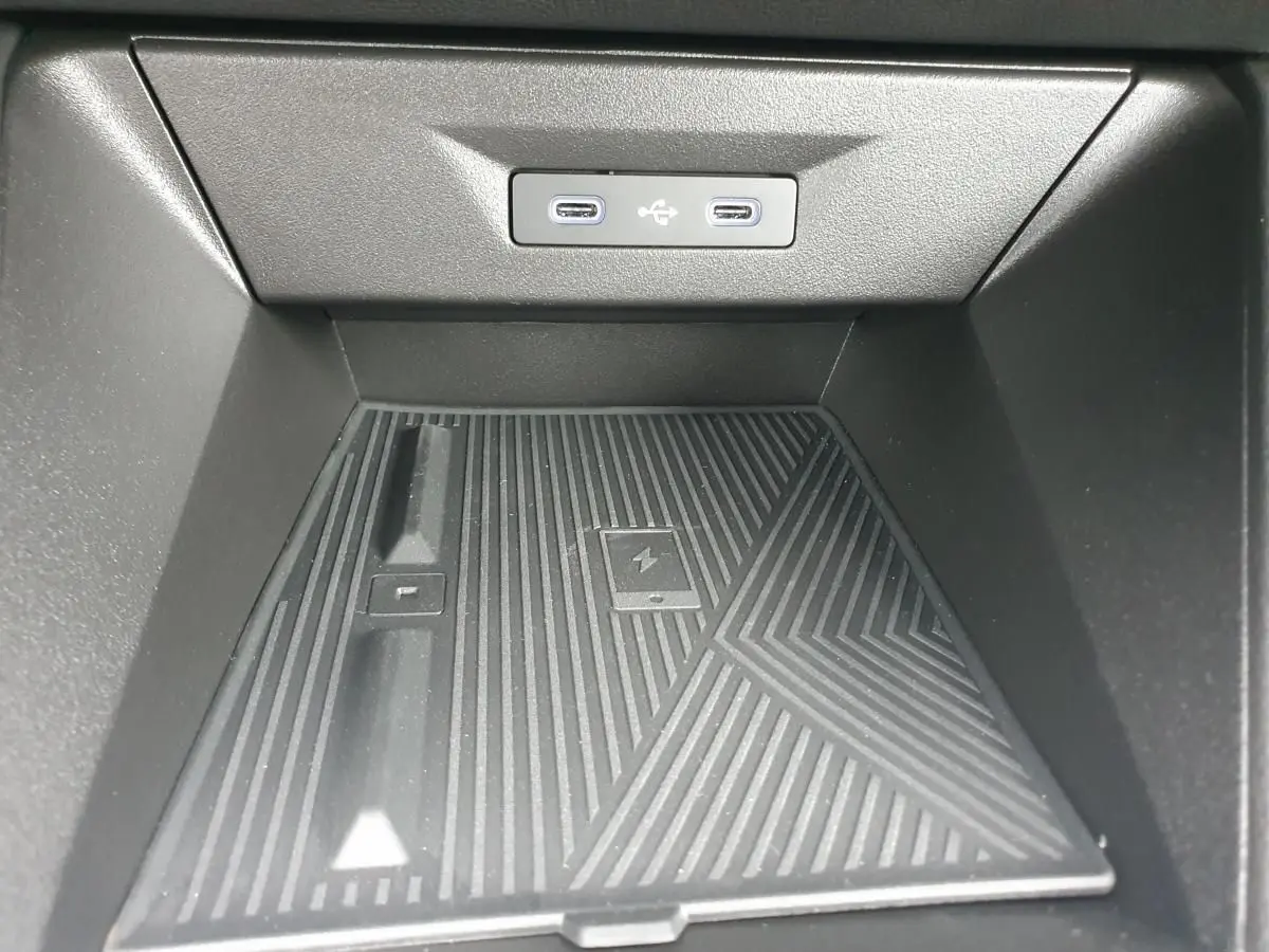 Détail de la console centrale avec deux prises USB-C rétroéclairées et surface de recharge sans fil dans une Renault Clio VI.