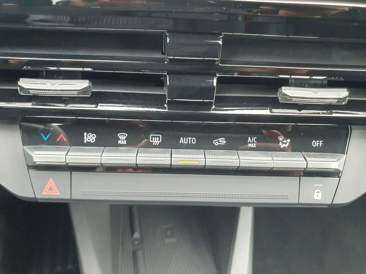 Détail de la console centrale de la Renault Clio VI hybride 2026, montrant les commandes de climatisation et ventilation.