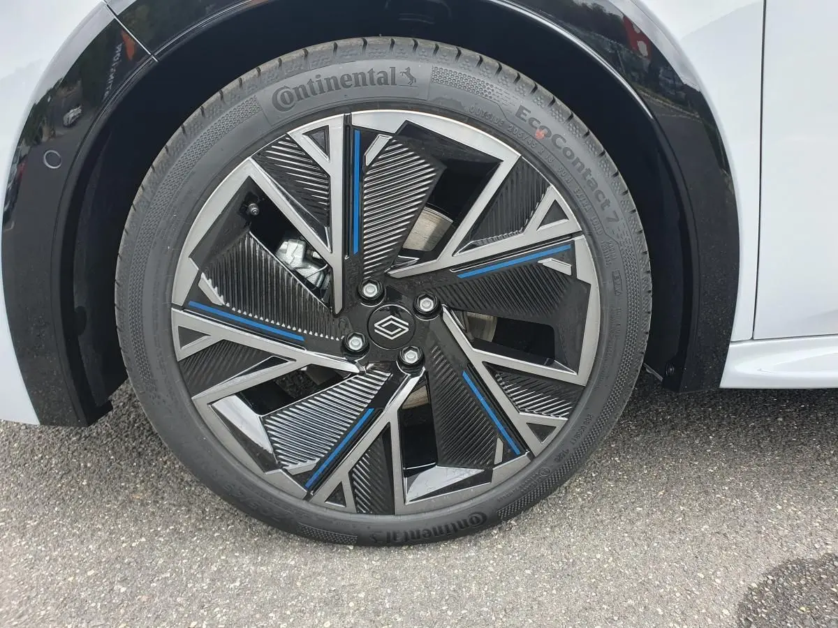 Gros plan sur la jante alliage 18” diamantée noire et bleue de la Renault Clio VI gris Rafale, pneu Continental visible.