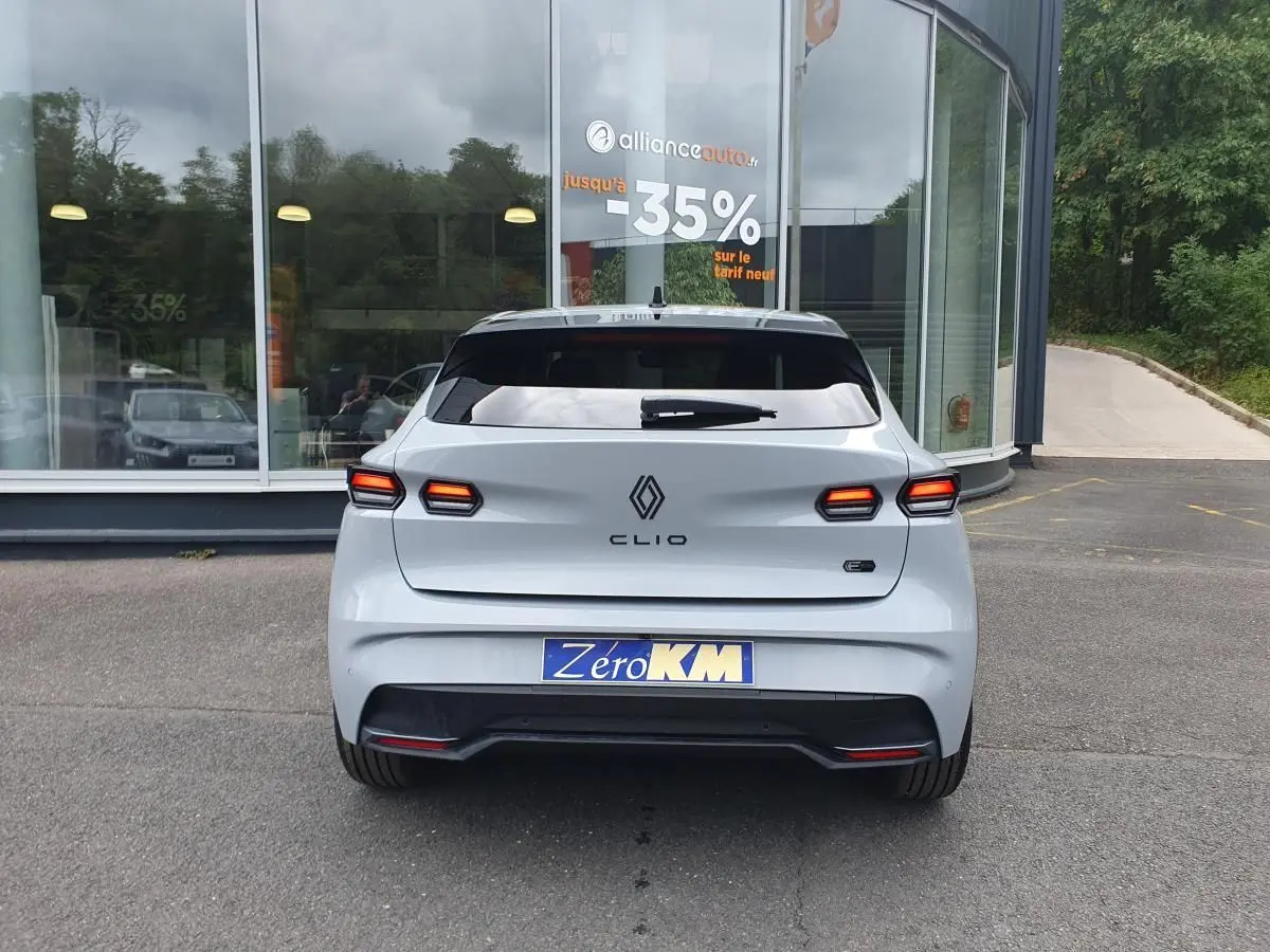 Vue arrière de la Renault Clio VI gris Rafale avec feux LED allumés et logo distinctif au centre du hayon.