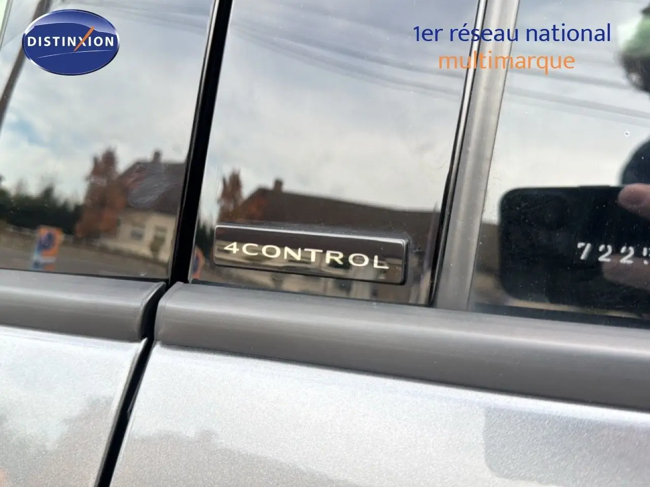 Gros plan sur l'insigne 4Control sur la porte arrière côté gauche d'un Renault Austral gris schiste avec toit noir.