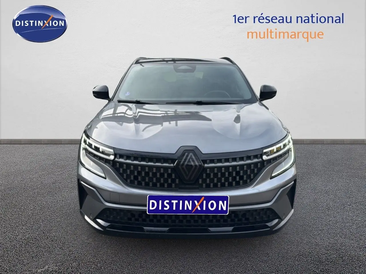 Vue frontale d'un Renault Austral gris schiste avec toit noir, calandre noire à motifs et phares LED distinctifs.