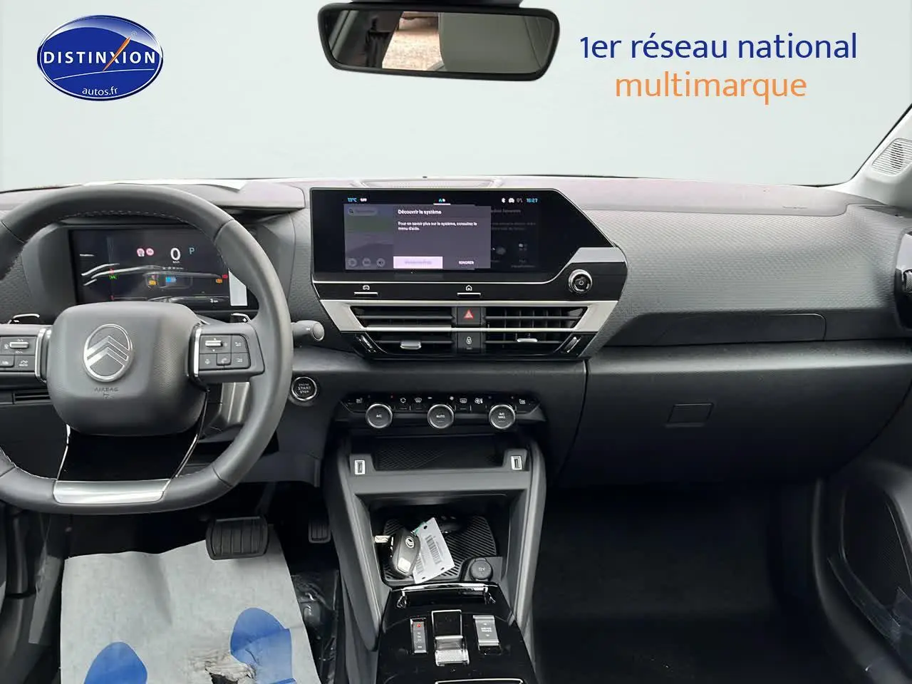 Vue intérieure avant du tableau de bord et volant cuir noir de la Citroën C4 1.2 hybride 2025 avec écran tactile et commandes intégrées.