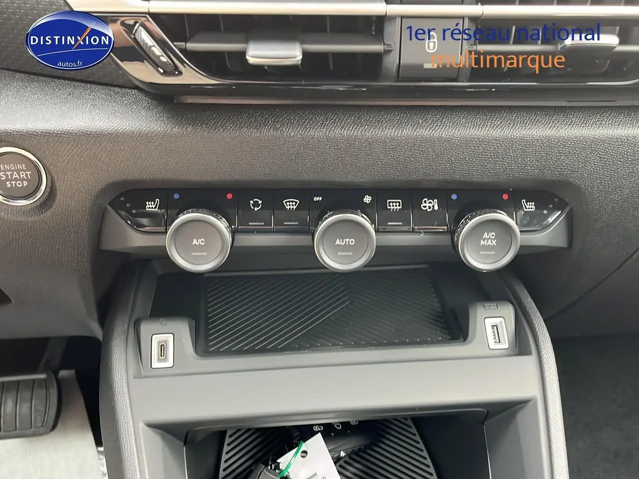 Gros plan sur la console centrale noire du Citroën C4 1.2 hybride 2025 avec commandes climatisation et bouton start/stop.