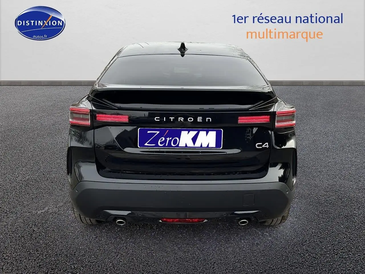 Vue arrière d'une Citroën C4 noire métal avec feux LED horizontaux et double sortie d'échappement visible.