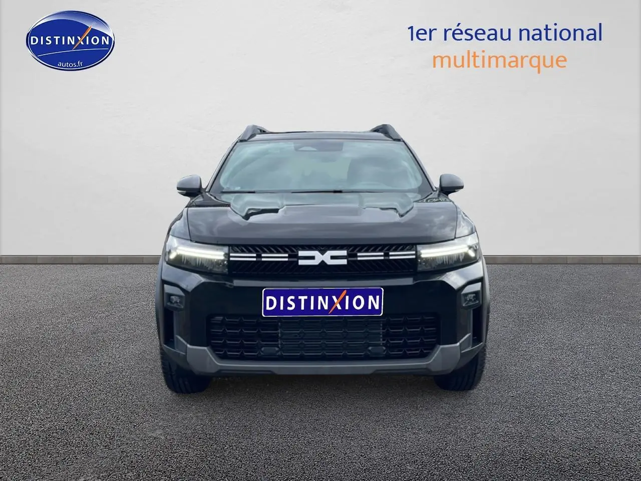 Vue de face du Dacia Bigster noir 2025 avec calandre distinctive et phares LED allumés sur fond neutre.