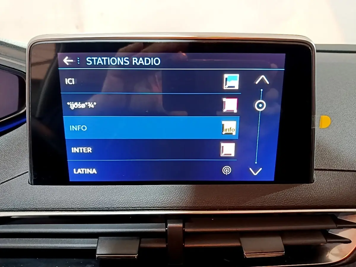 Écran tactile central affichant les stations radio dans l’habitacle d’un Peugeot 3008 gris clair, vue de face.