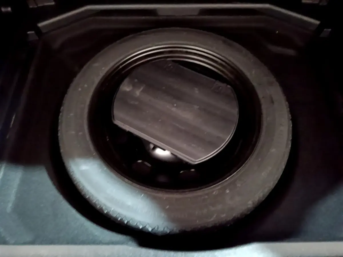 Gros plan sur la roue de secours noire dans le coffre d’un Peugeot 3008 gris clair, version Puretech 130 S&S.