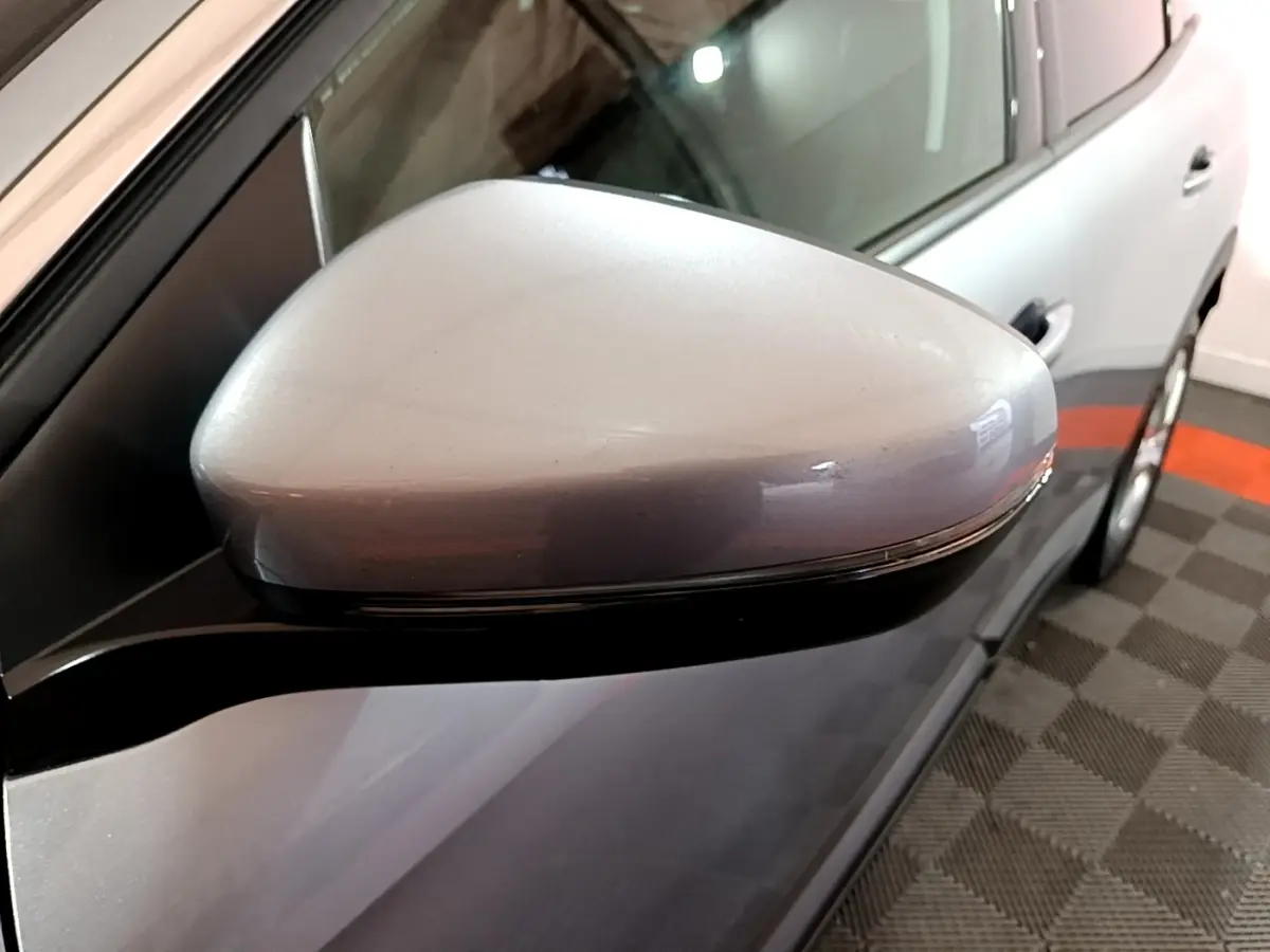 Gros plan sur le rétroviseur droit gris clair du Peugeot 3008 2020, avec portière et jante partiellement visibles.