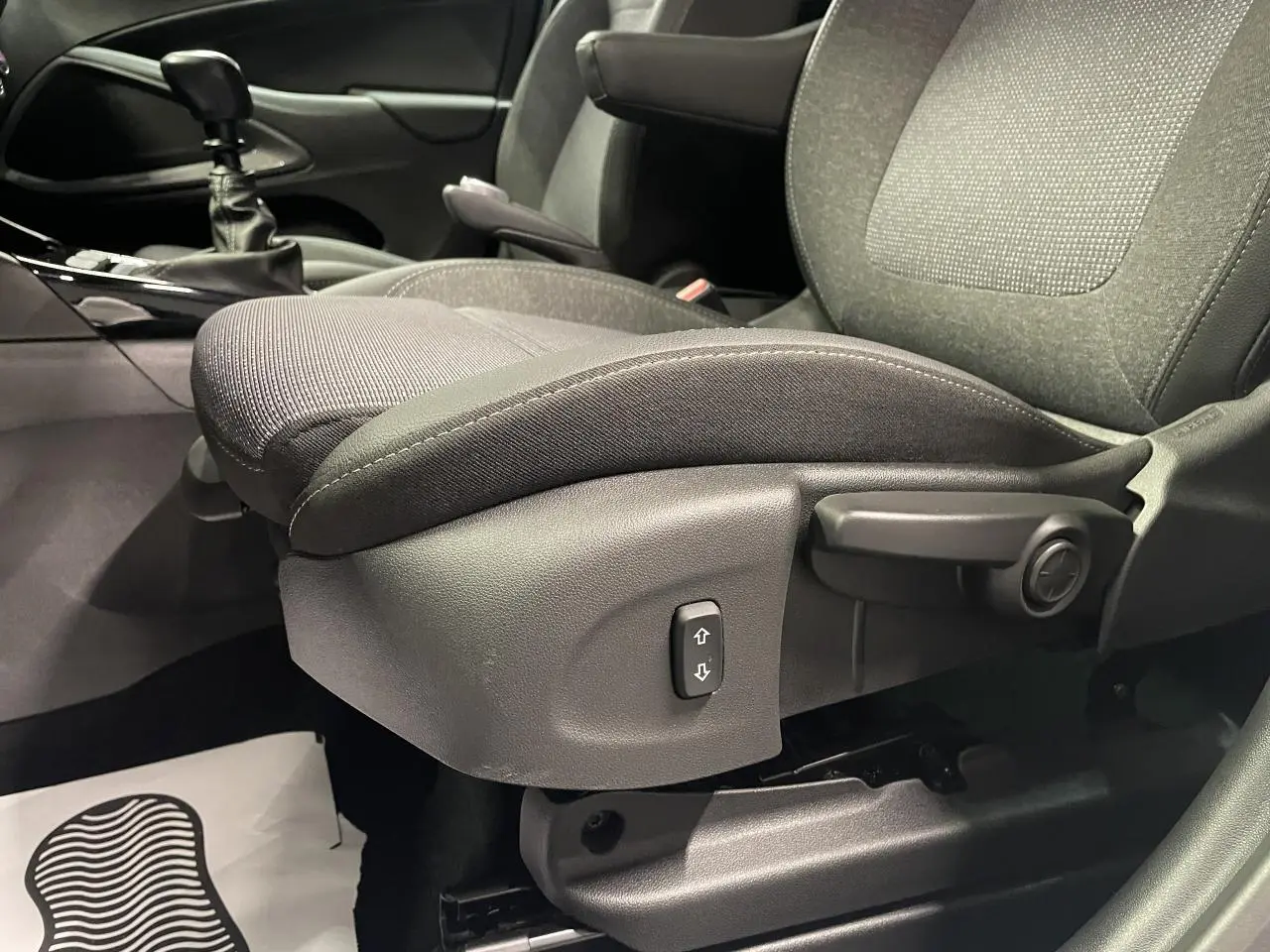 Gros plan sur le siège conducteur gris foncé de l’Opel Crossland 2024 avec commande de réglage manuel et levier d’accoudoir.