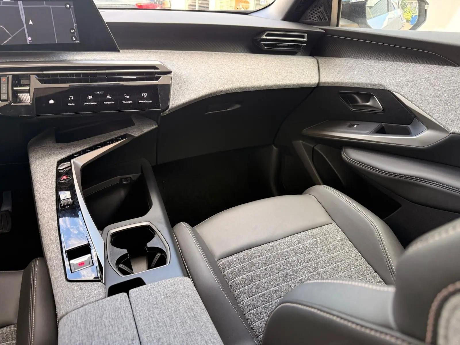 Vue intérieure côté passager du Peugeot 5008 Hybrid 145 finition Allure, avec sellerie grise et console centrale moderne.