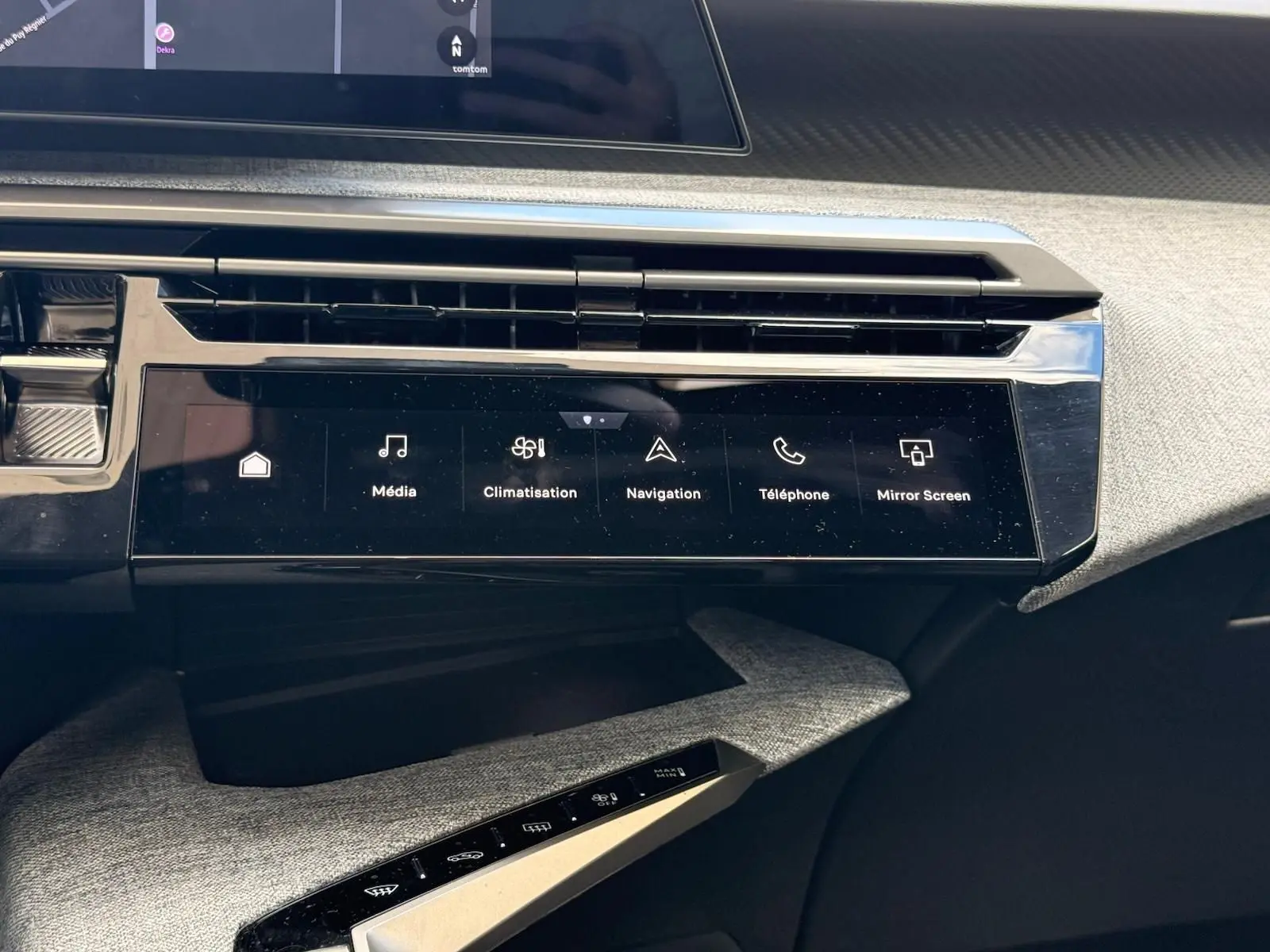 Vue rapprochée de la console centrale tactile noire du Peugeot 5008 gris Artense, affichant les commandes multimédia et climatisation.