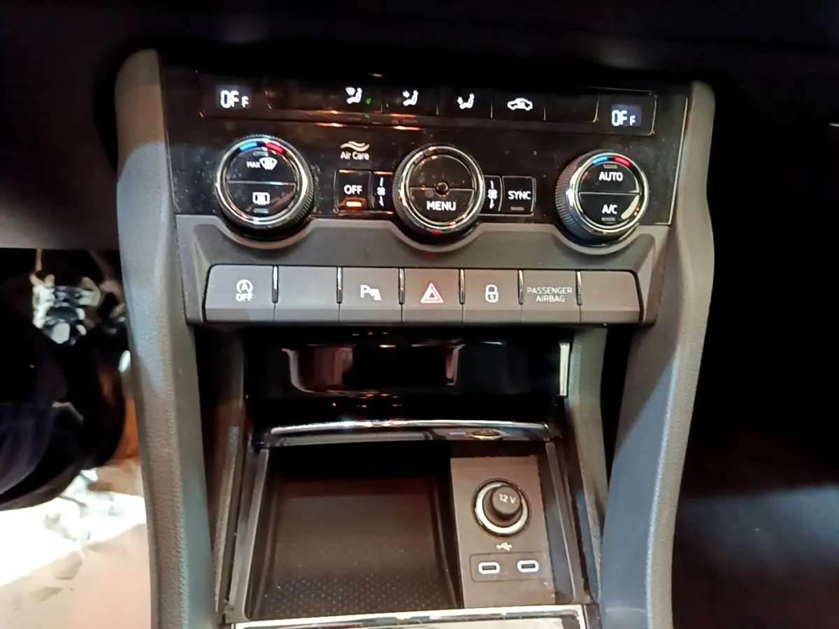 Vue rapprochée de la console centrale du Skoda Karoq 2022, avec commandes climatisation et prises USB visibles.