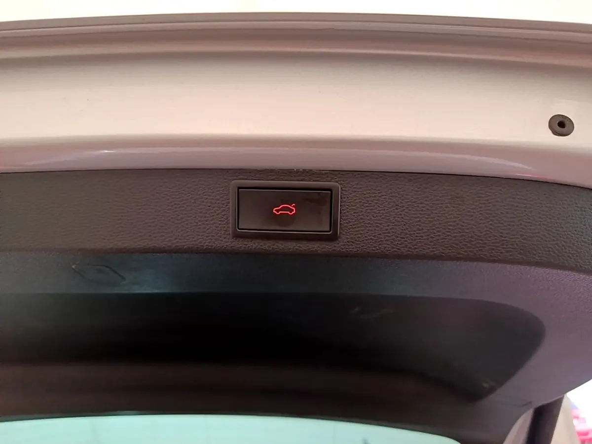 Bouton d'ouverture électrique du coffre sur la face intérieure du hayon d'un Skoda Karoq gris clair 2022.