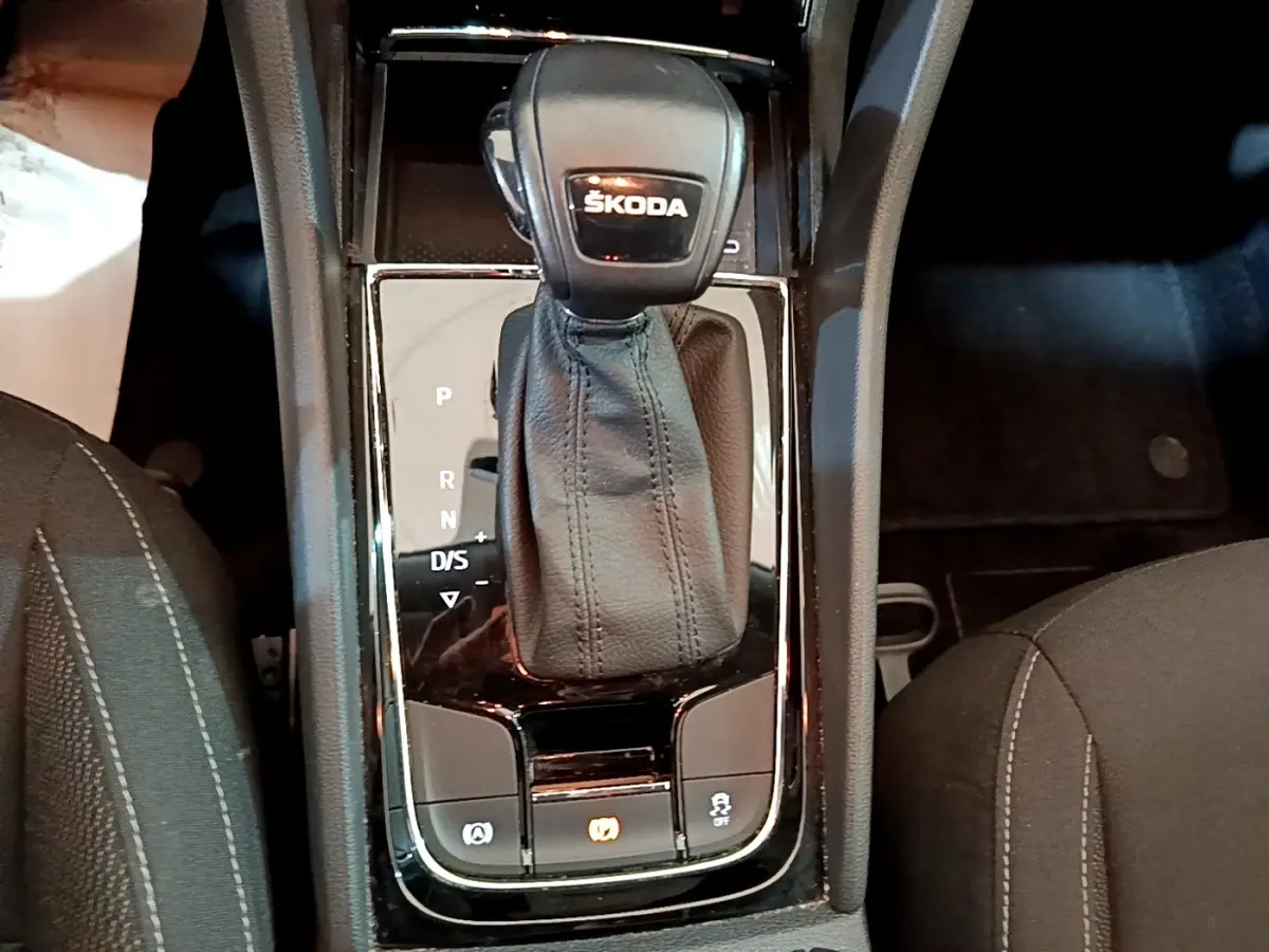 Gros plan sur la console centrale du Skoda Karoq gris clair, mettant en valeur le levier de vitesses automatique DSG7.