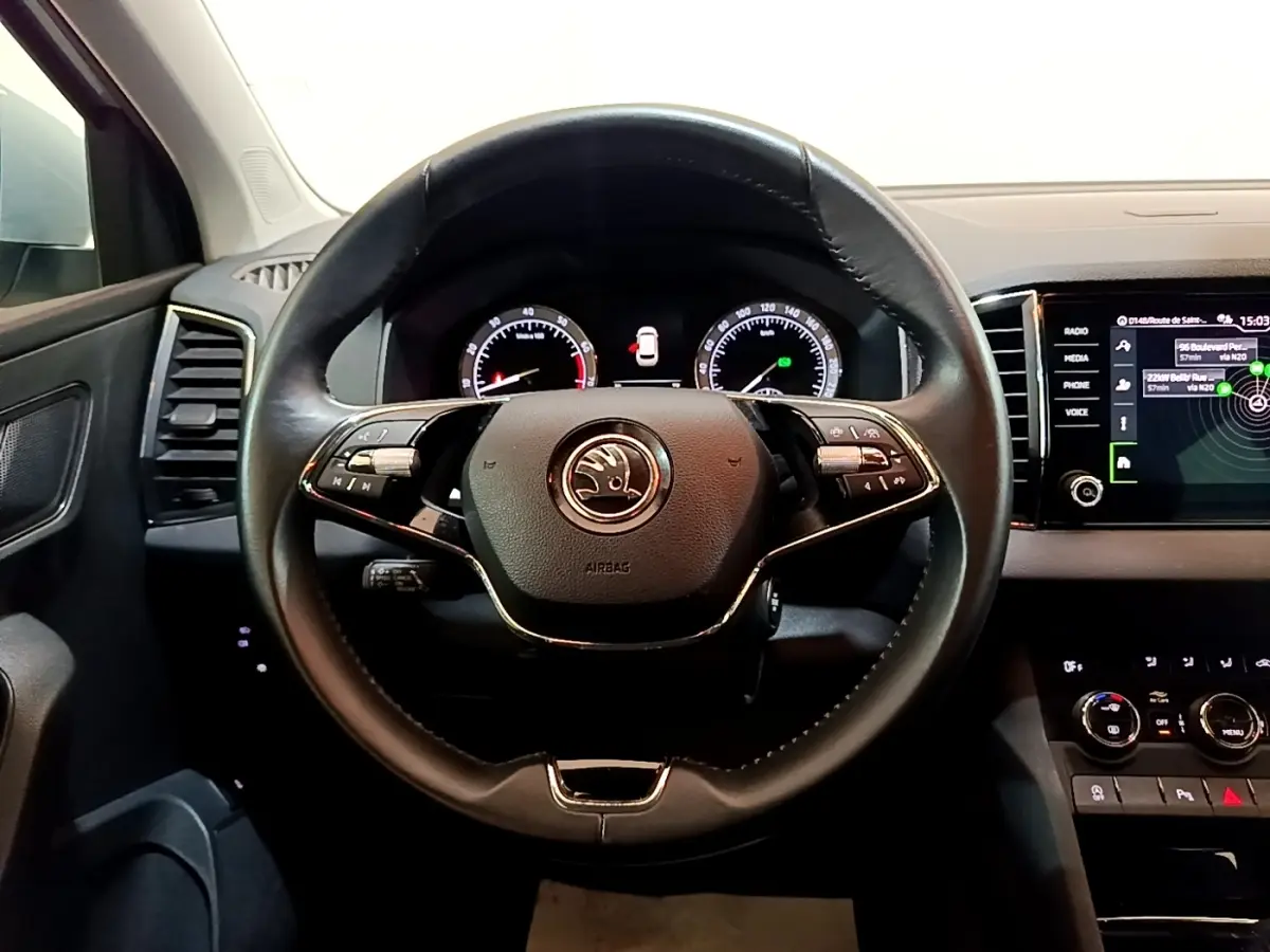 Vue centrée sur le volant cuir noir du Skoda Karoq 2022 avec tableau de bord digital et écran tactile à droite.