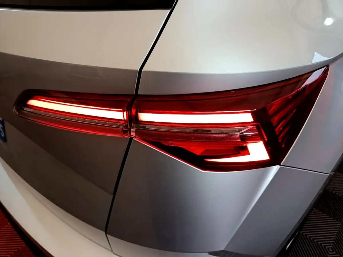 Gros plan sur le feu arrière droit allumé d’un Skoda Karoq gris clair, soulignant ses lignes anguleuses modernes.