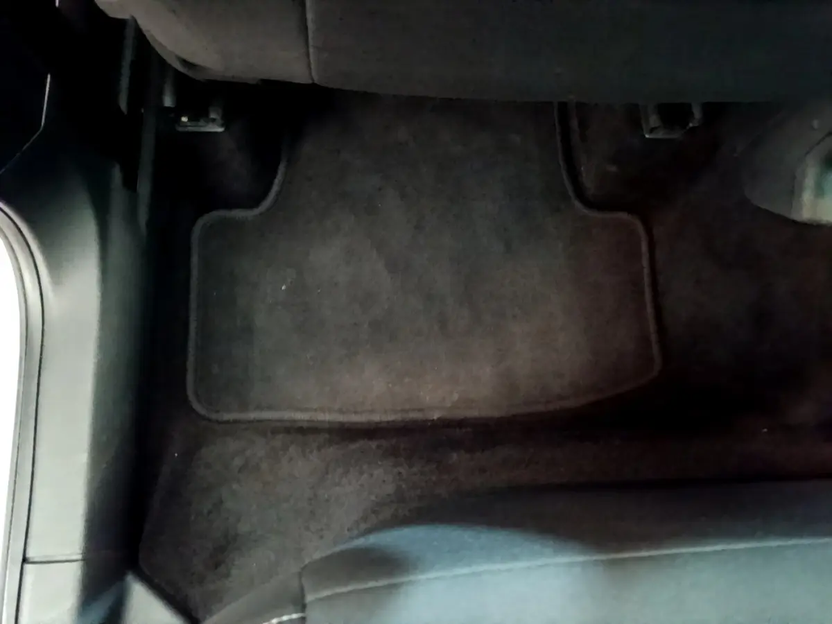 Vue rapprochée du tapis de sol noir côté conducteur dans un Skoda Karoq gris clair 2022.