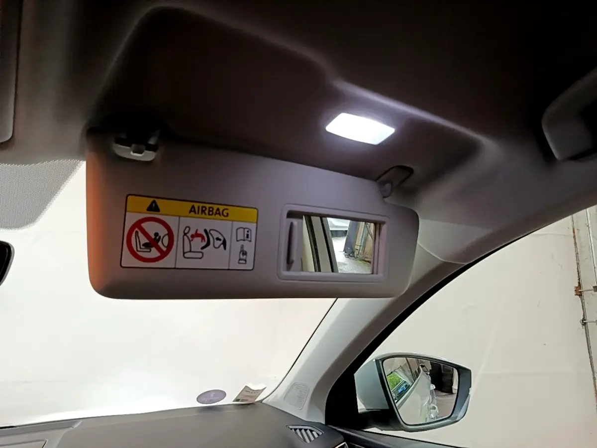 Vue intérieure du pare-soleil côté conducteur avec miroir et avertissement airbag sur Skoda Karoq gris clair 2022.