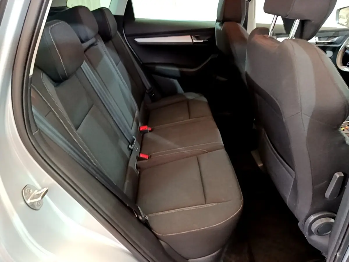 Vue intérieure côté gauche montrant la banquette arrière noire du Skoda Karoq gris clair 2022.