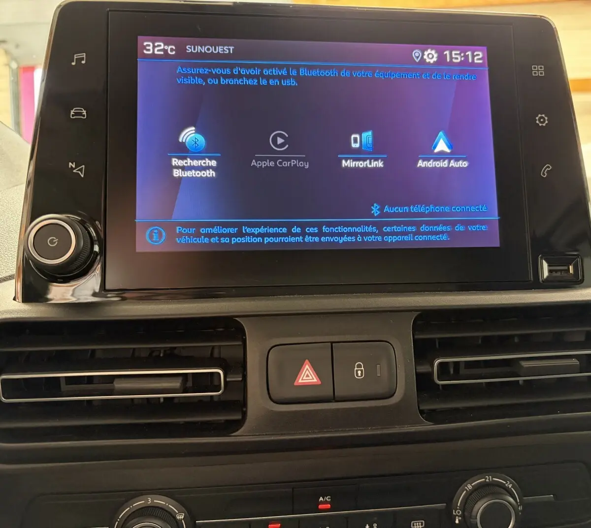 Écran tactile central du tableau de bord du Peugeot Rifter blanc 2021 affichant les options Bluetooth, Apple CarPlay et Android Auto.