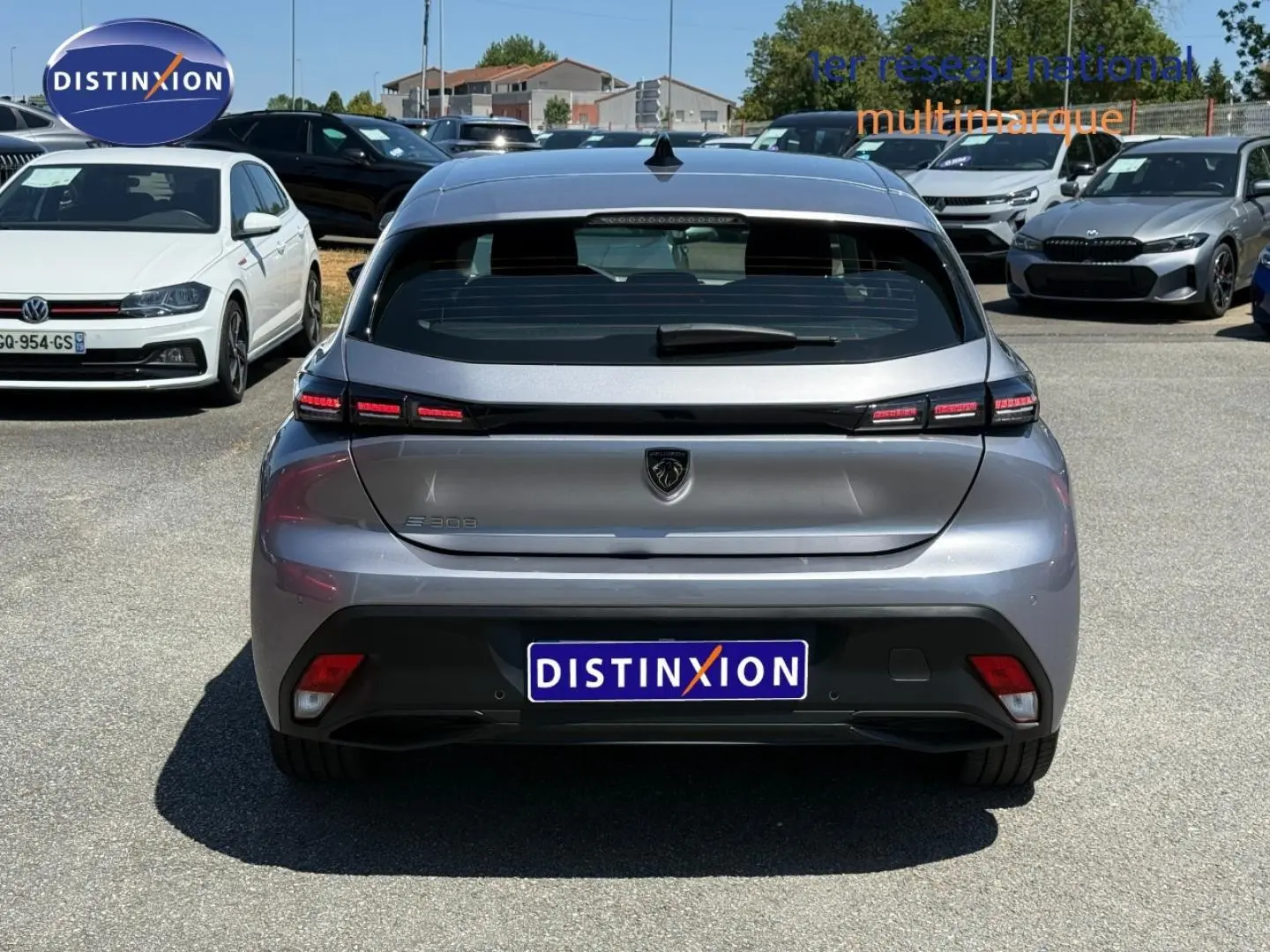 Vue arrière d'une Peugeot e-308 2025 gris métallisé, avec feux arrière LED et logo lion central.