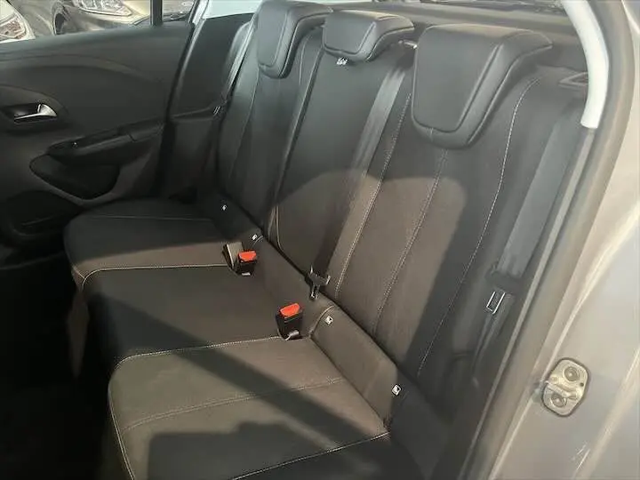 Vue intérieure côté arrière droit montrant les sièges noirs en tissu et cuir de l'Opel Corsa gris métal 2021.