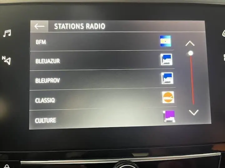 Écran tactile intérieur de l’Opel Corsa 1.2T 2021 affichant la liste des stations radio avec interface moderne.