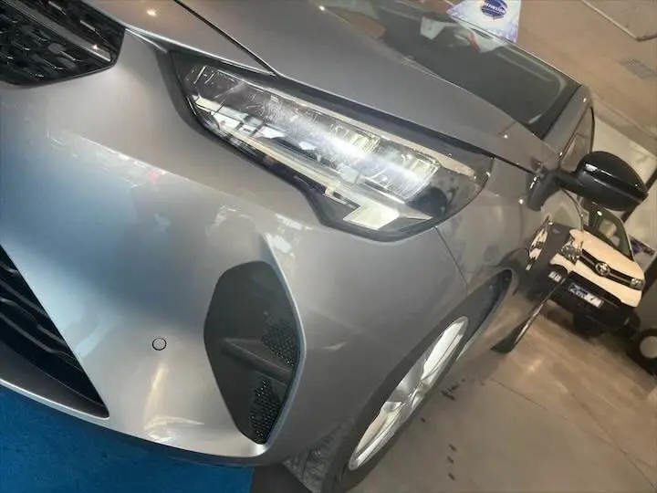 Vue rapprochée du 3/4 avant droit d'une Opel Corsa gris métal avec phares LED et calandre noire brillante.