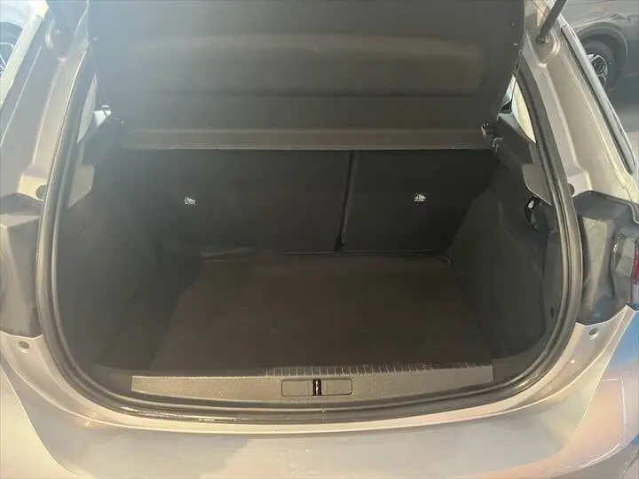 Coffre ouvert vu de l'arrière d'une Opel Corsa gris métal 2021, espace de chargement vide et propre.