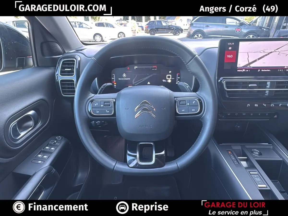 Vue intérieure centrée sur le volant cuir noir et le tableau de bord numérique du Citroën C5 Aircross noir 2025.