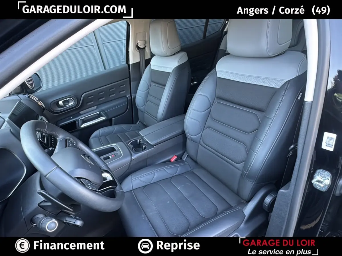 Vue intérieure côté conducteur du Citroën C5 Aircross noir 2025, sièges cuir bicolore et volant multifonctions.