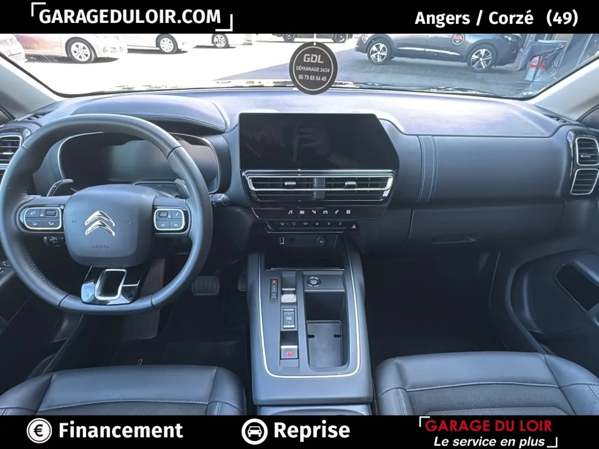 Vue intérieure avant du Citroën C5 Aircross noir, tableau de bord moderne avec écran tactile central et volant cuir multifonctions.