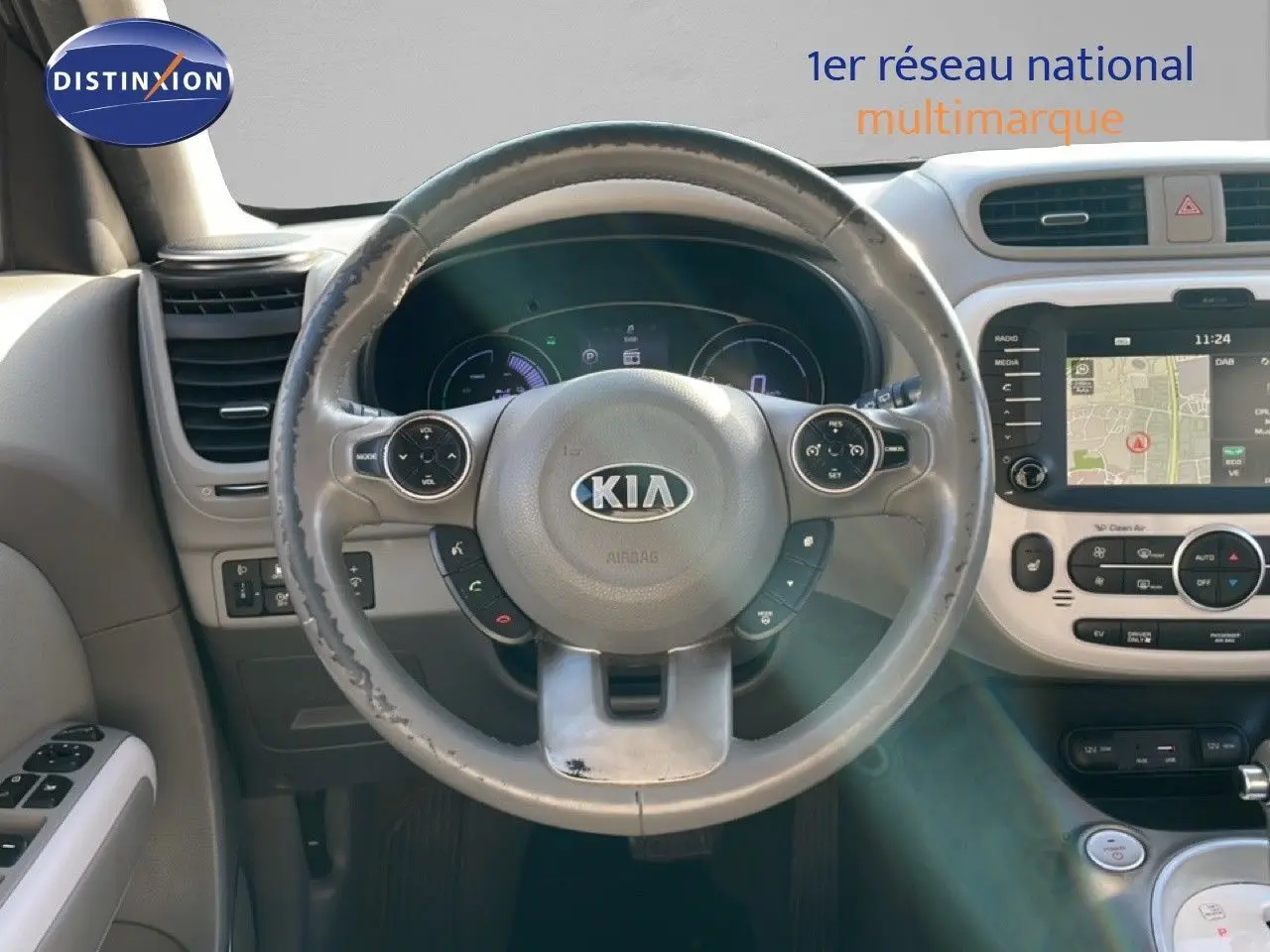Vue intérieure centrée sur le volant gris du Kia Soul EV 2016 avec tableau de bord numérique et écran tactile GPS.