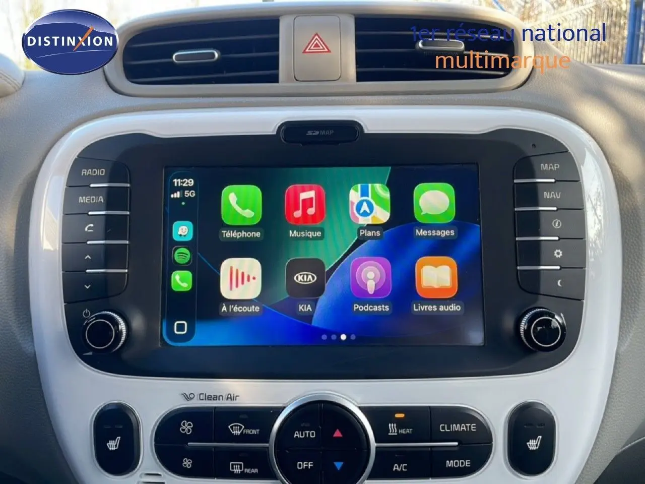 Vue rapprochée de l’écran tactile central et des commandes de climatisation du Kia Soul EV noir Shadow Metal avec toit rouge.