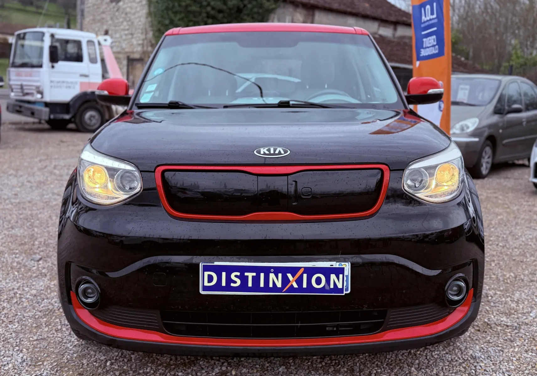 Vue de profil côté gauche du Kia Soul EV électrique noir Shadow Metal avec toit rouge, roues au design spécifique.