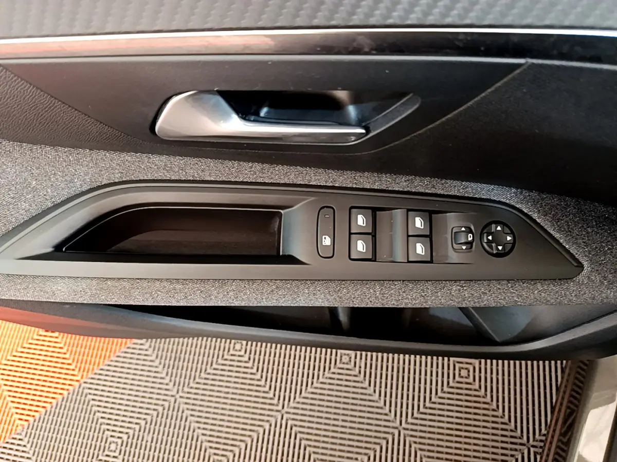 Commande des vitres et rétroviseurs sur la porte intérieure côté conducteur du Peugeot 3008 gris foncé, finition tissu.