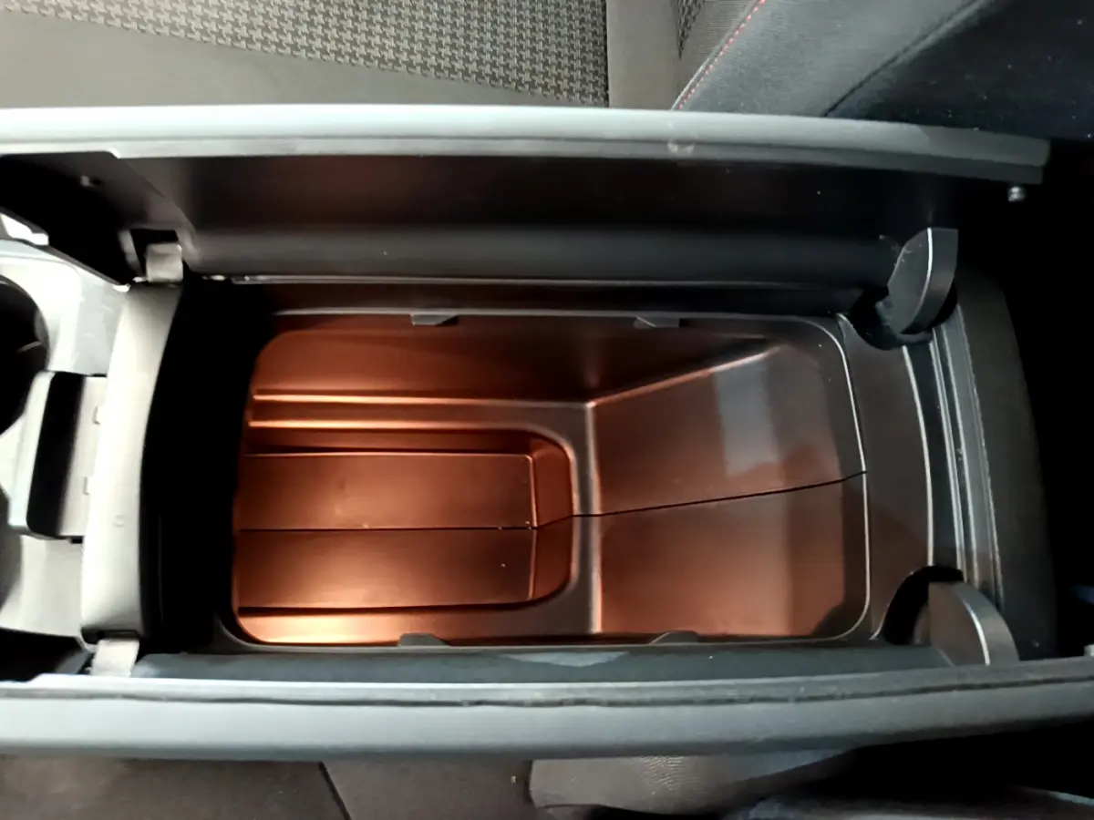 Vue en plongée du rangement réfrigéré noir dans l'accoudoir central du Peugeot 3008 gris foncé Puretech 130 S&S ACTIVE.