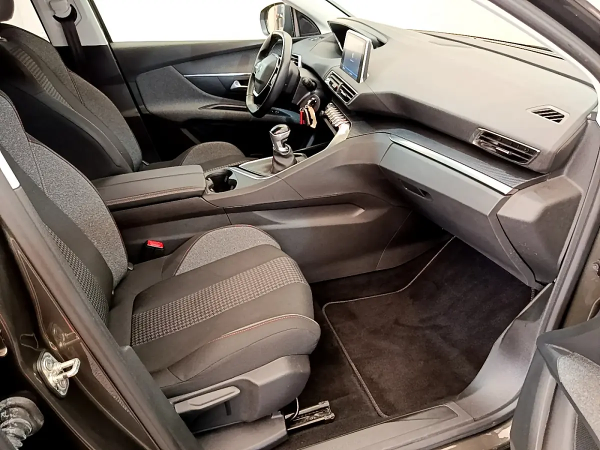 Intérieur avant droit du Peugeot 3008 gris foncé 2020, montrant sièges tissu, tableau de bord et écran tactile central.