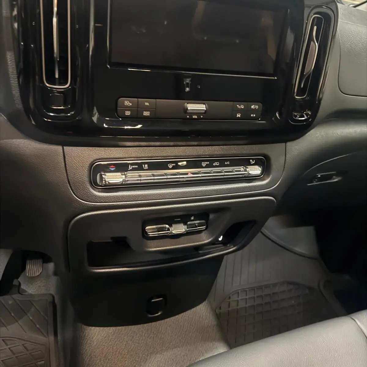 Vue rapprochée du tableau de bord noir du Mercedes Vito Mixto 2025, mettant en valeur l'écran tactile et les commandes de climatisation.