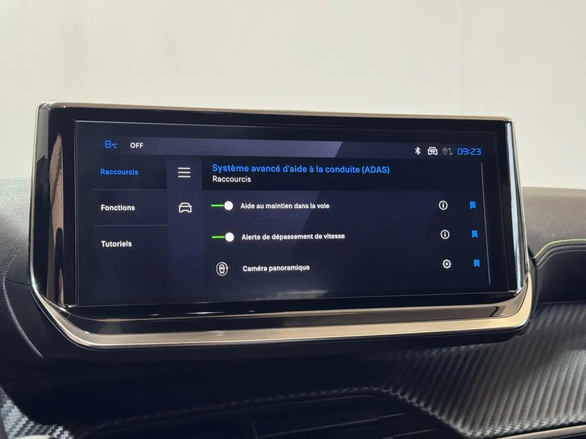 Écran tactile central affichant les aides à la conduite dans l’habitacle d’une Peugeot 208 Hybrid gris clair.