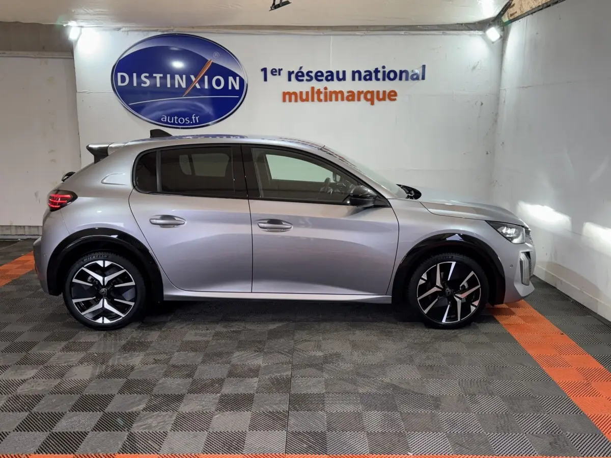 Profil droit de la Peugeot 208 Hybrid 136 eDCS6 GT gris clair, avec jantes noires et détails modernes visibles.