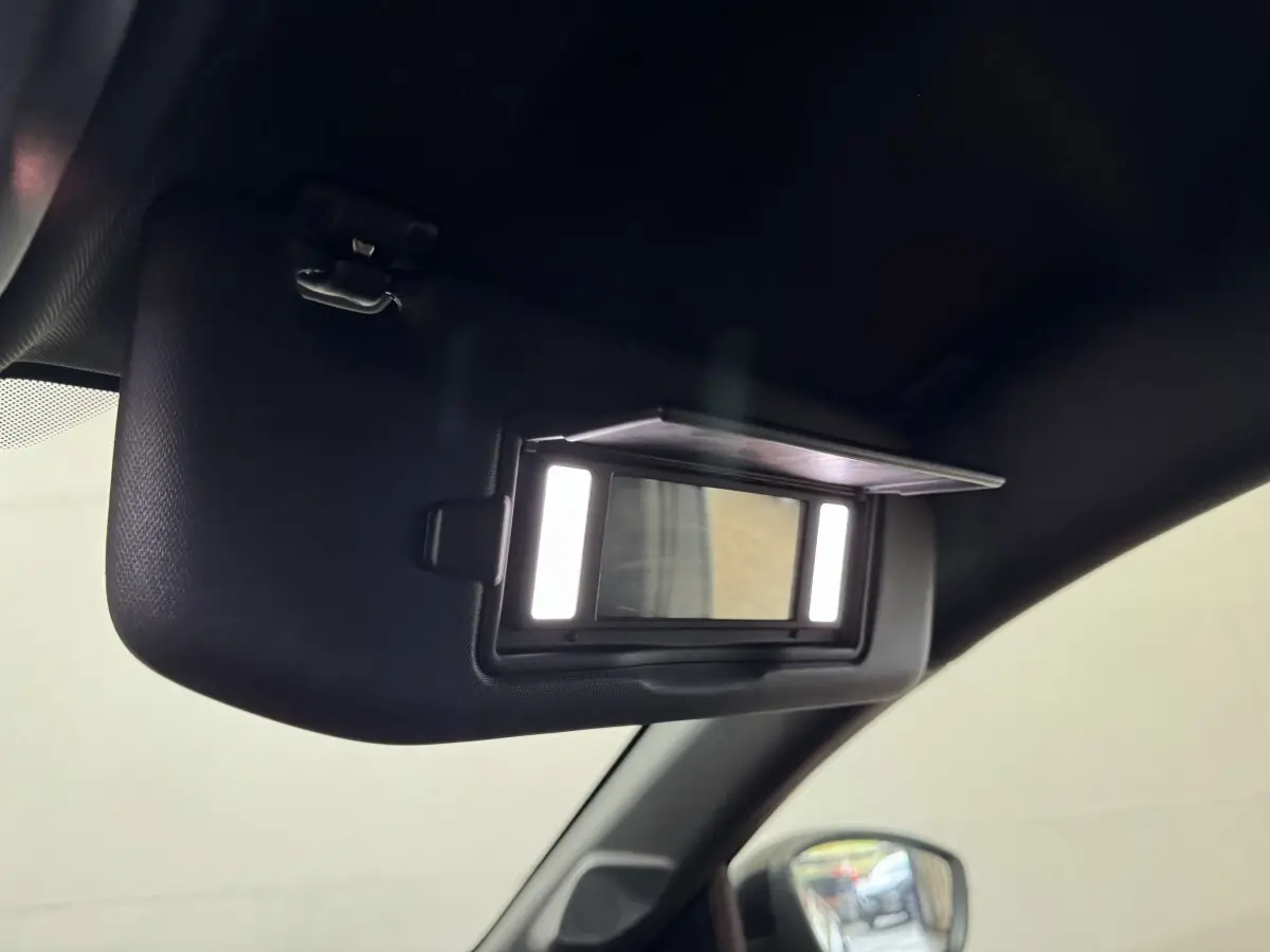Détail intérieur du pare-soleil avec miroir éclairé sur Peugeot 208 Hybrid 136 eDCS6 GT, vue côté conducteur.