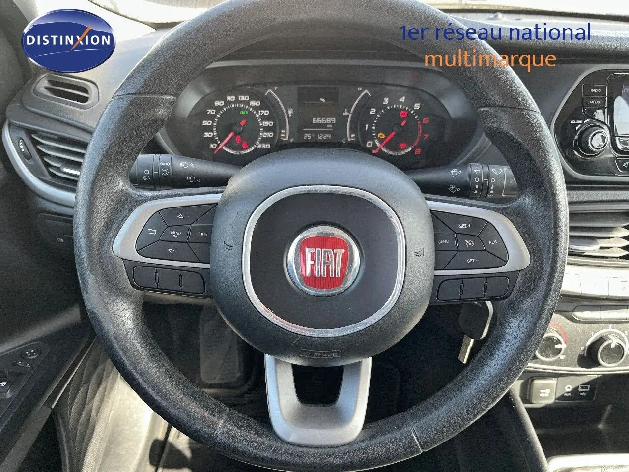 Vue intérieure centrée sur le volant noir de la Fiat Tipo 5 portes 2018, avec tableau de bord et commandes visibles.