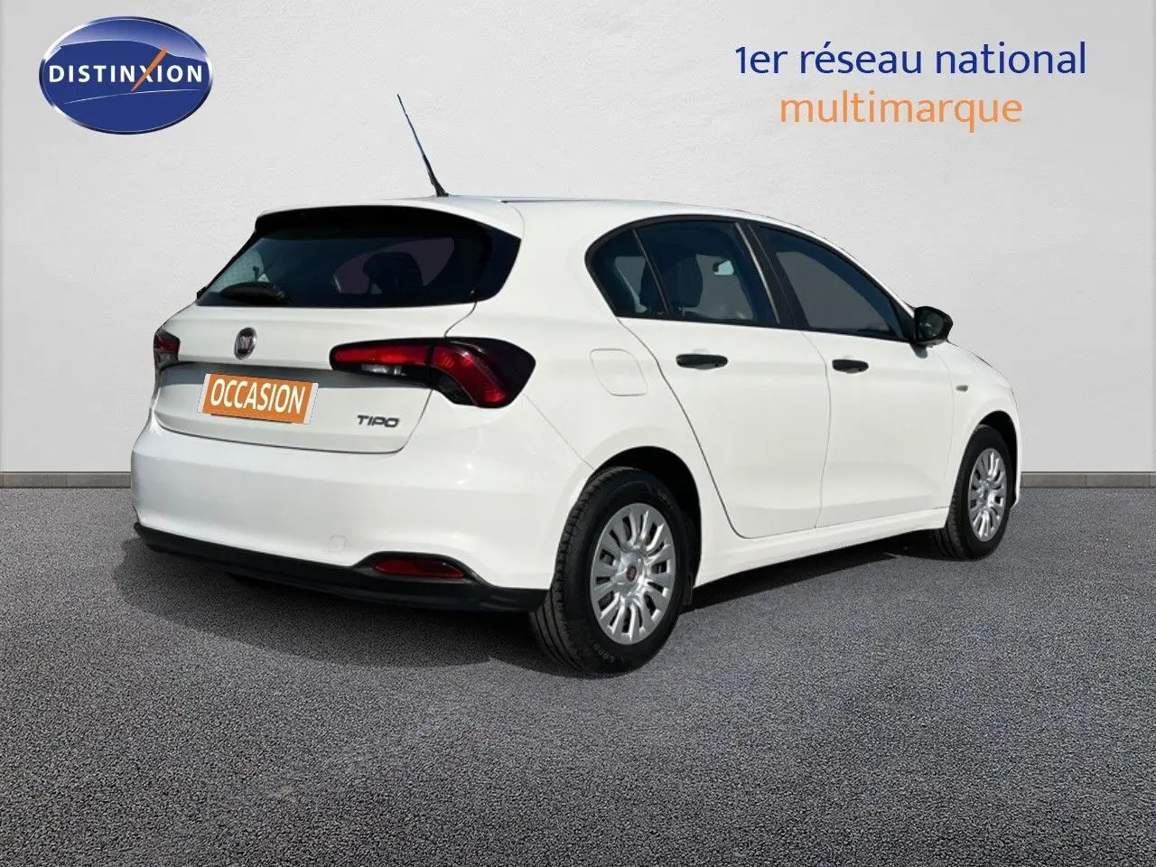 Vue 3/4 arrière droite d'une Fiat Tipo 5 portes blanche de 2018 avec logo et plaque occasion visible.