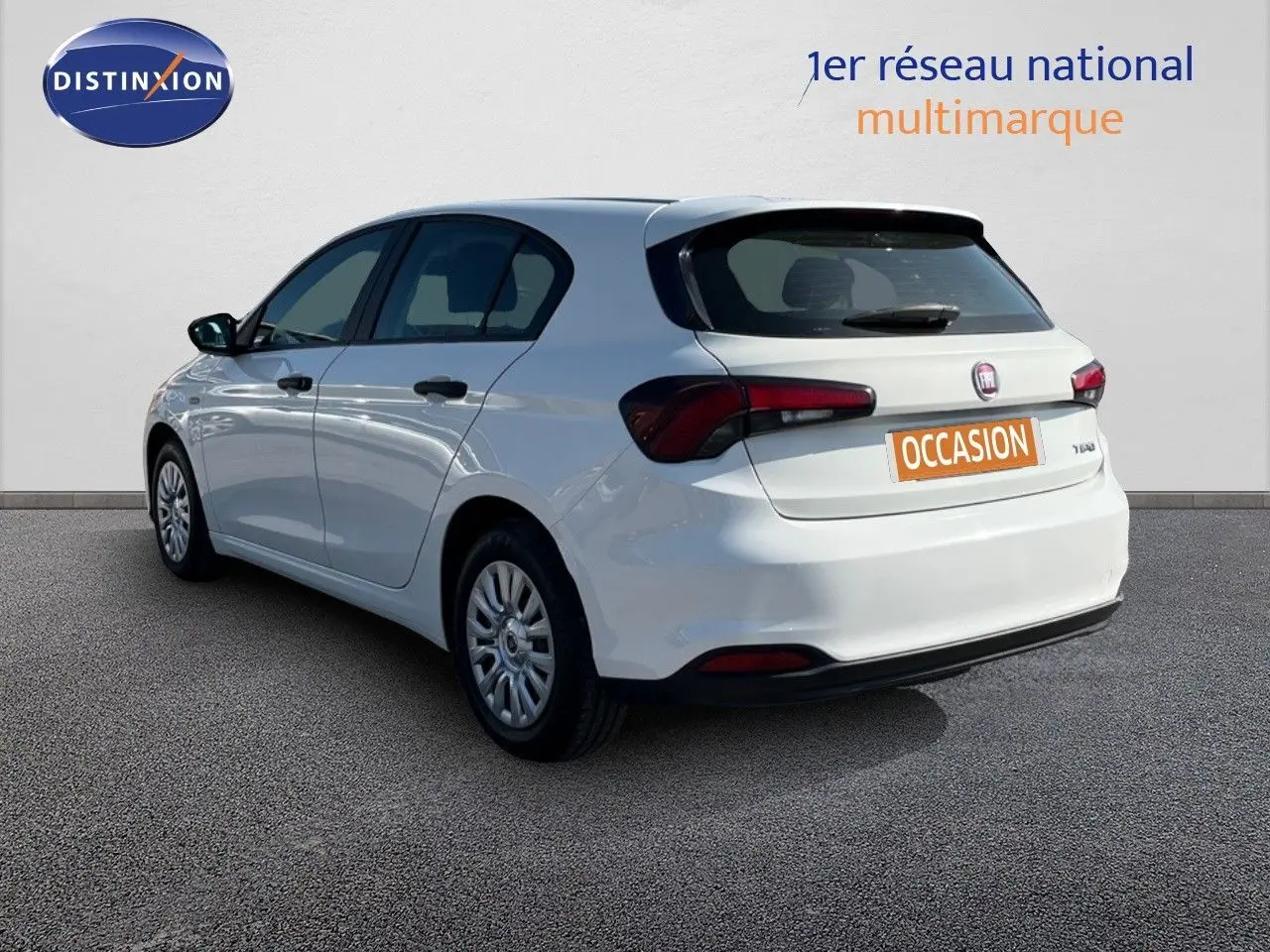 Vue 3/4 arrière droite d'une Fiat Tipo 5 portes blanche de 2018 avec plaques occasion et feux arrière foncés.