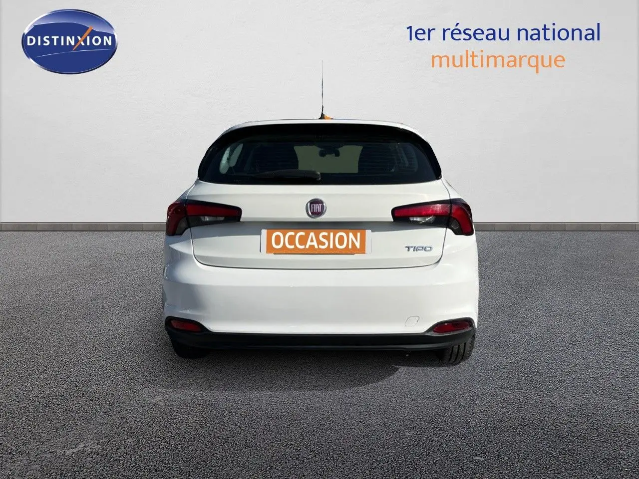 Vue arrière d'une Fiat Tipo 5 portes blanche de 2018 avec logo et feux arrière distinctifs, stationnée sur sol gris.