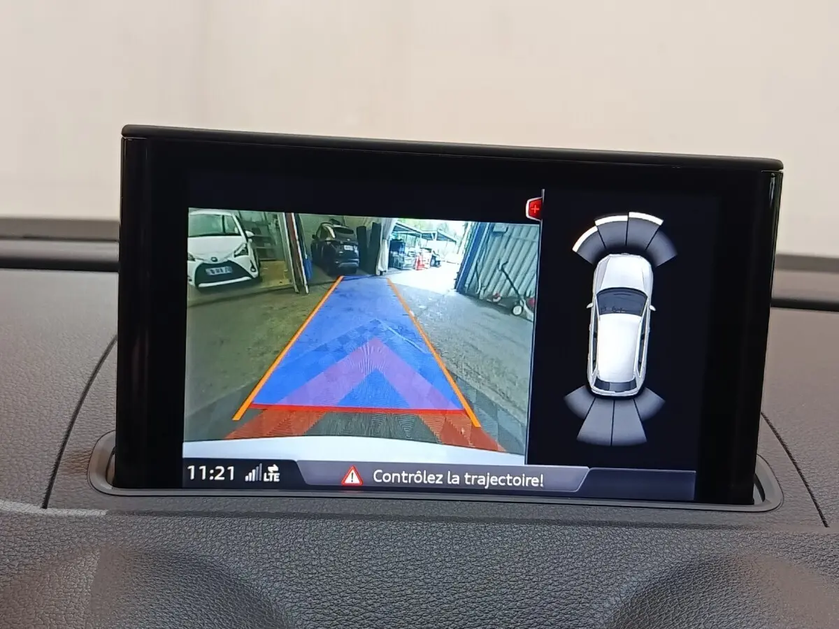 Écran tactile intérieur montrant la caméra de recul et l’aide au stationnement d’un Audi A3 blanc.