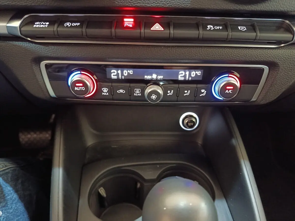 Vue rapprochée du tableau de bord et de la console centrale noire de l’Audi A3 35 TDI, montrant la climatisation digitale et les commandes.