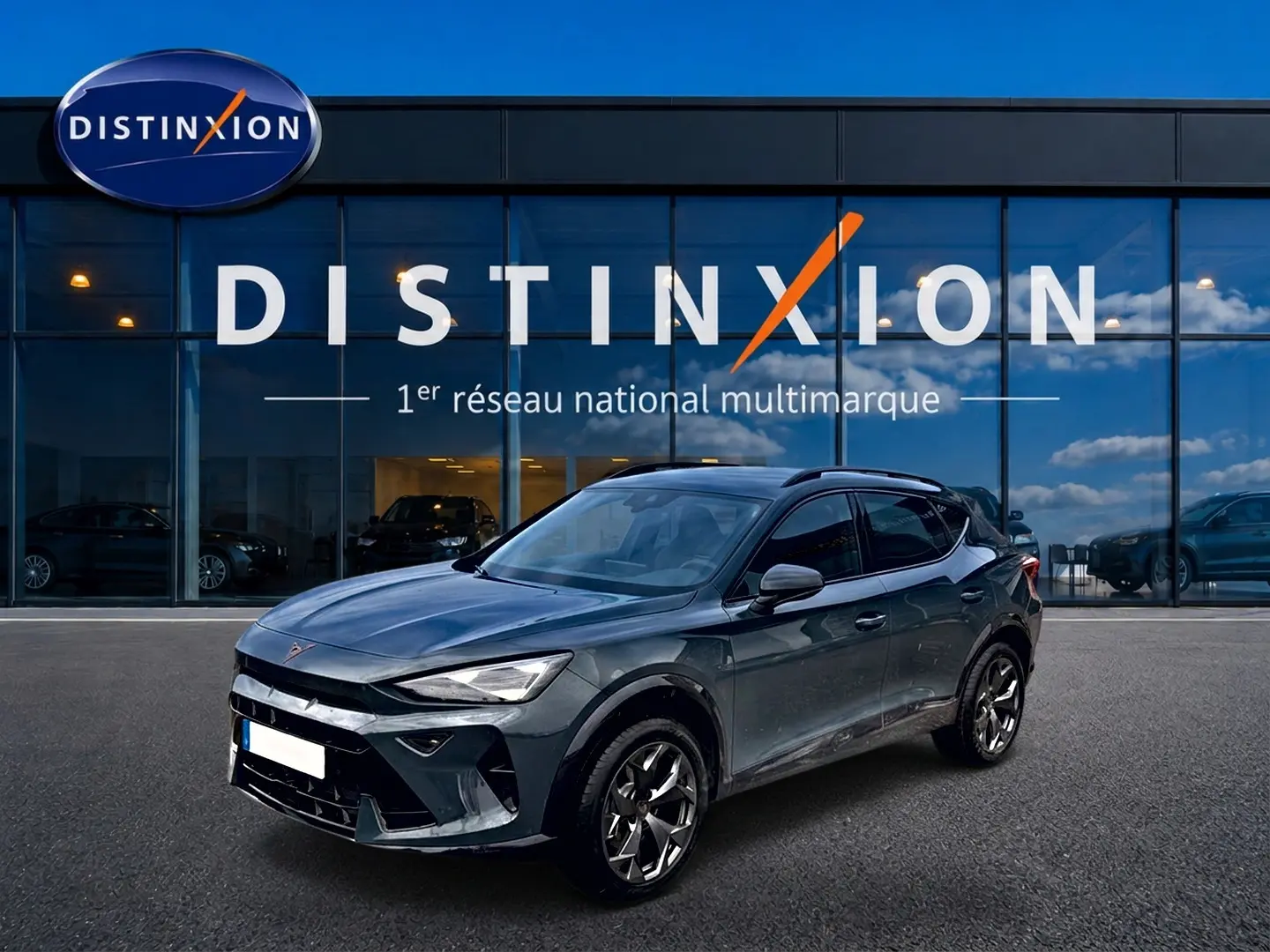 Vue 3/4 avant d'un CUPRA Formentor bleu fjord 2026 avec jantes noires, stationné devant une vitrine Distinxion.